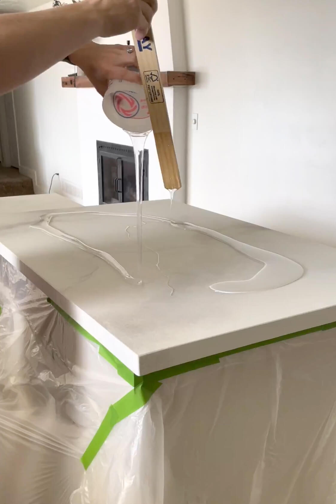 Pouring epoxy onto a DIY faux marble island countertop.